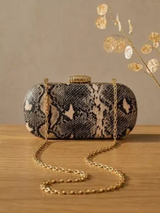 Premium brown snakeskin party clutch for women resting on a wooden table
