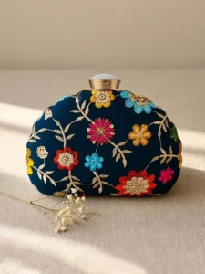 Navy Blue Floral Image: Clutiva navy blue premium handbag with multi-colored vibrant floral embroidery.