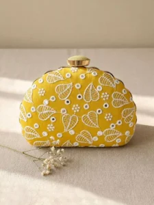 Yellow Leaf Image: Clutiva vibrant yellow wedding clutch bag with white mirror-work leaf embroidery.