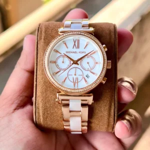 Close-up shot of the Clutiva Sofie rose gold chronograph watch on a woman's wrist, paired beautifully with a gold luxury designer pattern bangle.