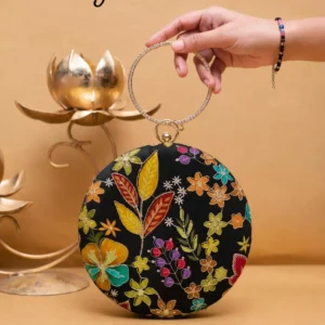 Clutiva Velvet Iris luxury round clutch in deep royal purple with magenta and violet floral embroidery, featuring a crystal-studded gold ring handle.